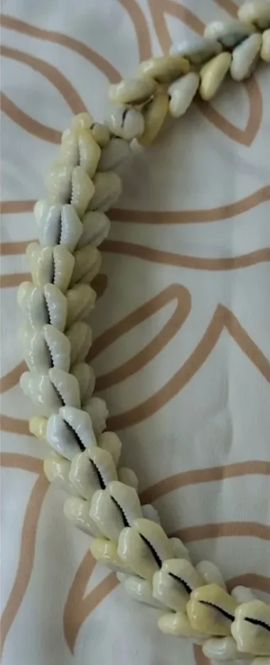 Collier formé d’une rangée serrée de porcelaines couleur crème.